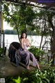 A woman sitting on a chair in front of a lake.